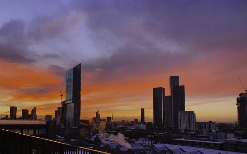 City skyline beneath orange and violet evening clouds