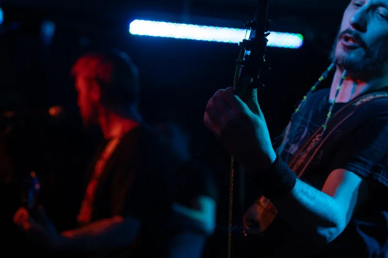 Musicians performing under blue and red stage lighting